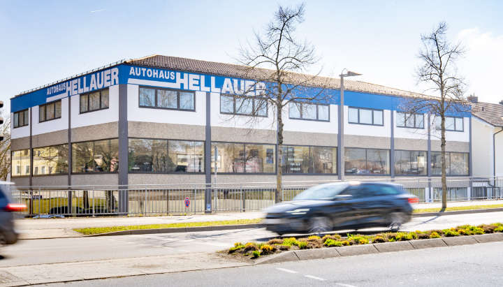 Aktuelles Außenfoto des Autohauses Hellauer mit blauer Beschriftung an der Fassade.